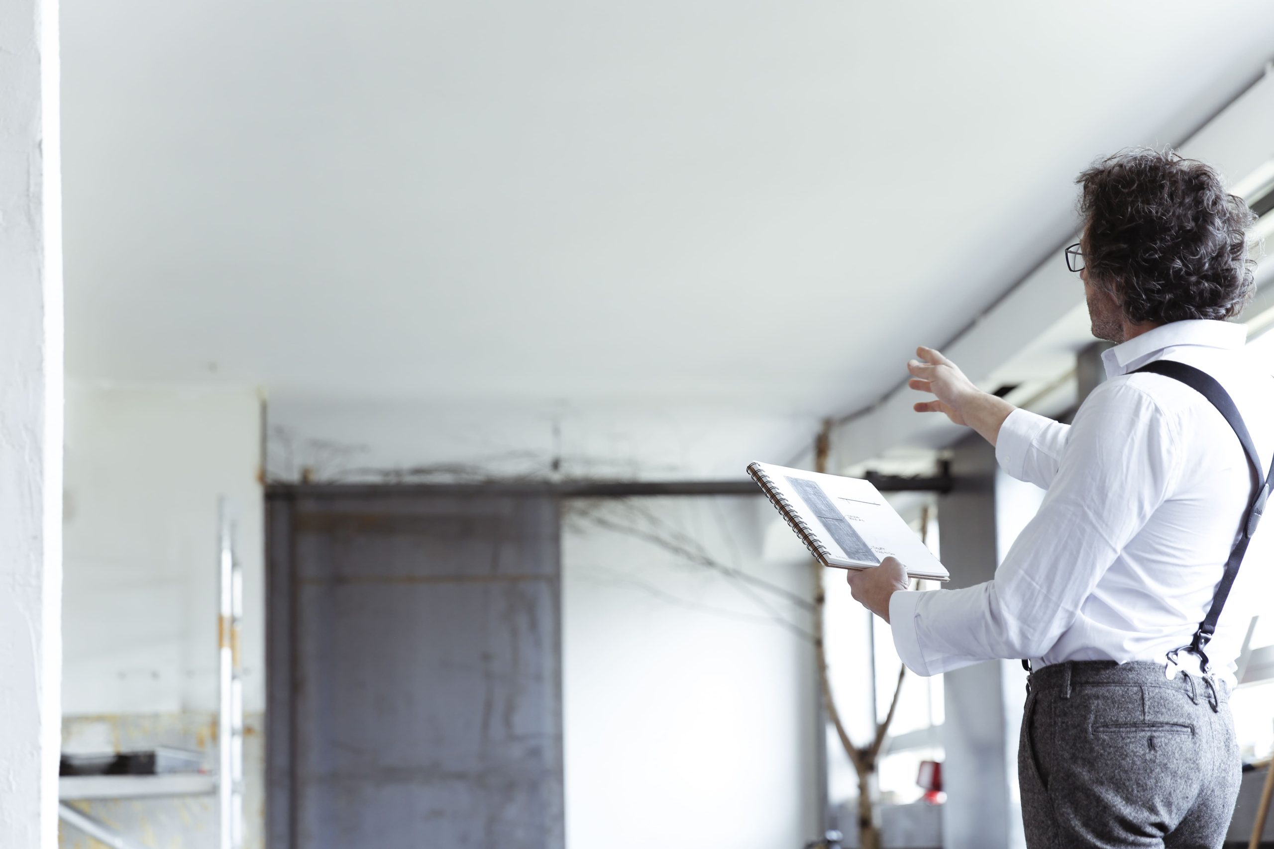 professional inspecting blueprint at construction